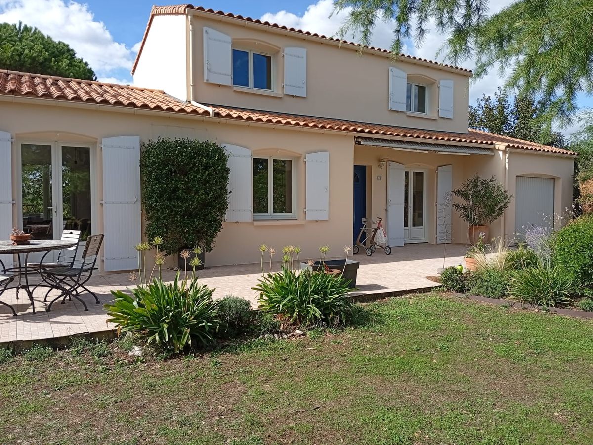 Maison aux façades beiges et volets clairs après ravalement par PRSV